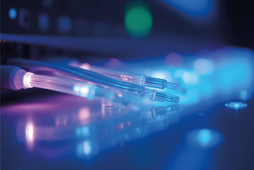 Zoom sur des câbles à fibre optique éclairés, utilisés dans les réseaux professionnels à haut débit.