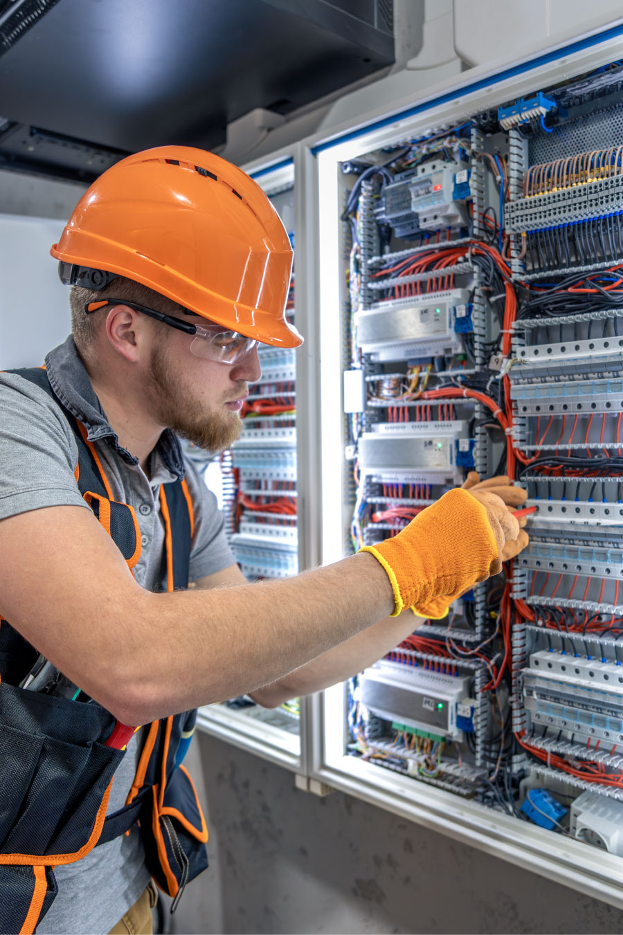 Technicien télécom en train de raccorder des lignes dans une armoire technique, câblages et équipements